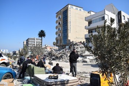 Στους δρόμους δίπλα στα ερείπια, σε ντιβάνια και καναπέδες, οικογένειες περιμένουν για τους νεκρούς τους ή για μια χαραμάδα ελπίδας...