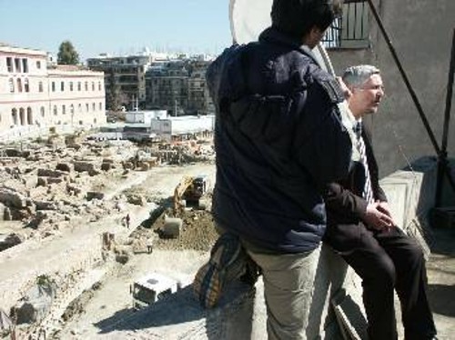 Ο νυν υφυπουργός Πολιτισμού, Π. Τατούλης, σε φωτογραφία του Μάρτη του 2003, ως βουλευτής της ΝΔ, με φόντο την ανασκαφή του Μακρυγιάννη. Λίγους μήνες πριν τη φωτογραφία έγραφε στο υπόμνημά του ότι «το έργο (σ.σ. το ΝΜΑ) για να ολοκληρωθεί θα καταστρέψει ολοσχερώς σύμφωνα με κατατεθειμένες μελέτες τον ανασκαμμένο χώρο. Συνεπώς πρόκειται για καταστροφικό έργο»...