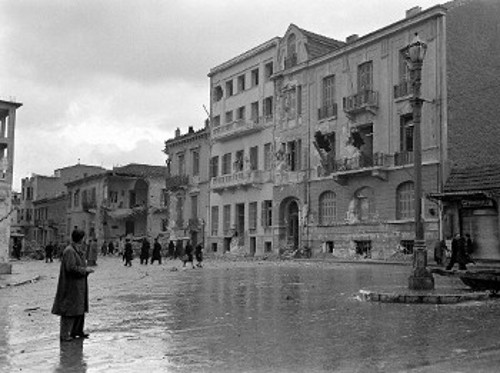 Φωτογραφία της πλατείας Κάνιγγος, κατά τη διάρκεια του ηρωικού Δεκέμβρη 1944, μετά από μια μάχη μεταξύ ΕΛΑΣιτών και Βρετανών. Σ' ένα απ' αυτά τα οδοφράγματα θα συλληφθεί ο εικοσάχρονος ΕΠΟΝίτης δημιουργός (Φωτ.: Ντμίτρι Κέσελ)