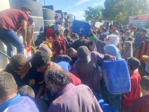 Οικογένειες με παιδιά περπατούν τεράστιες αποστάσεις μέσα στη ζέστη και τα ερείπια αναζητώντας λίγο νερό...