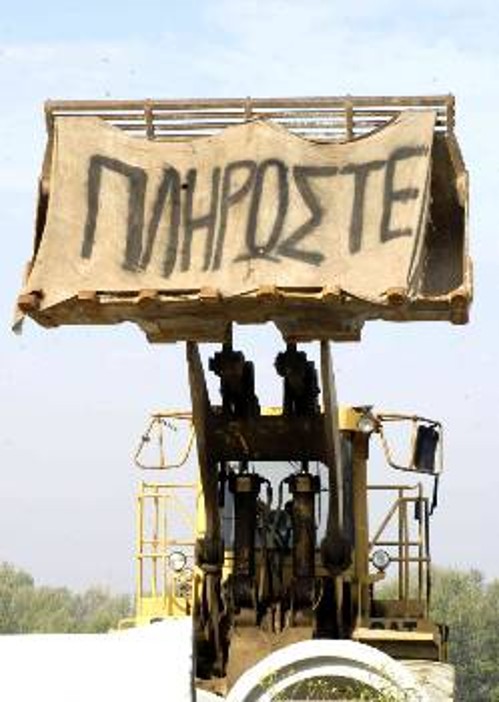 Το πανό που κρέμασαν οι εργαζόμενοι στον «κουβά» του φορτωτή τα λέει όλα...