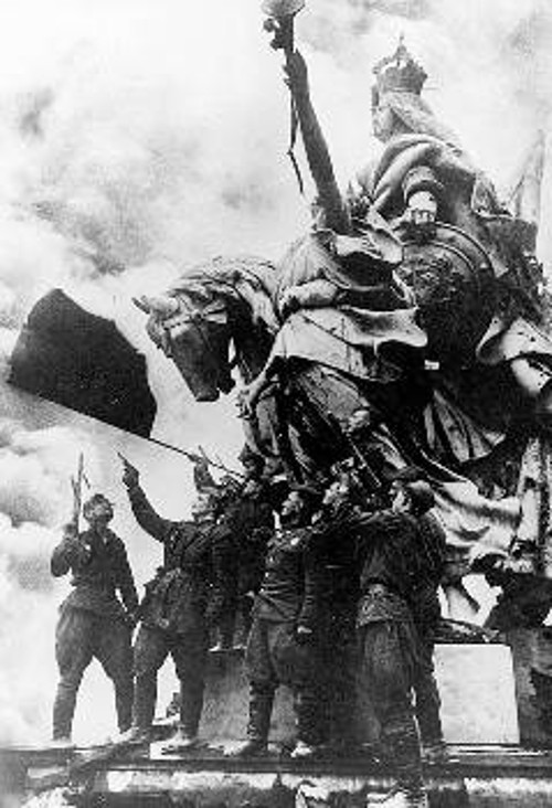 Σοβιετικοί μαχητές πανηγυρίζουν για την κόκκινη σημαία που υψώθηκε στο Ράιχσταγκ