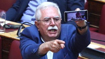 Ο Χρ. Κατσώτης από τα έδρανα της Βουλής δείχνει στον υπουργό τις φωτογραφίες σκελετωμένων παιδιών στη Γάζα