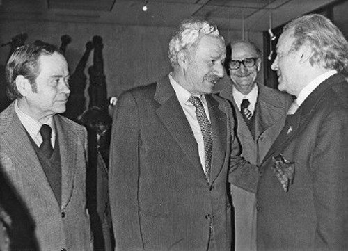 Ο αείμνηστος ΓΓ της ΚΕ του ΚΚΕ Χαρίλαος Φλωράκης συνομιλεί με τον Μέμο Μακρή, υπό το βλέμμα του χαράκτη Τάσσου και του καπετάνιου της Αντίστασης Νίκανδρου Κεπέση (Αρχείο «Ριζοσπάστη»)