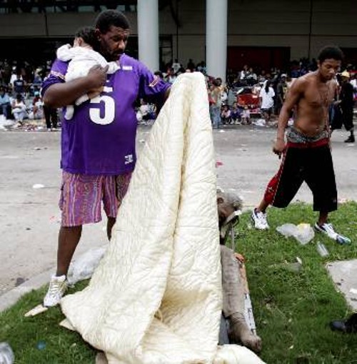Με το μωρό στο ένα χέρι, και με το άλλο να καλύπτεις τον συνάνθρωπό σου που ξεψύχησε μέσα(!) στο προσωρινό καταφύγιο του σταδίου «Σούπερντομ» της Λουιζιάνα...
