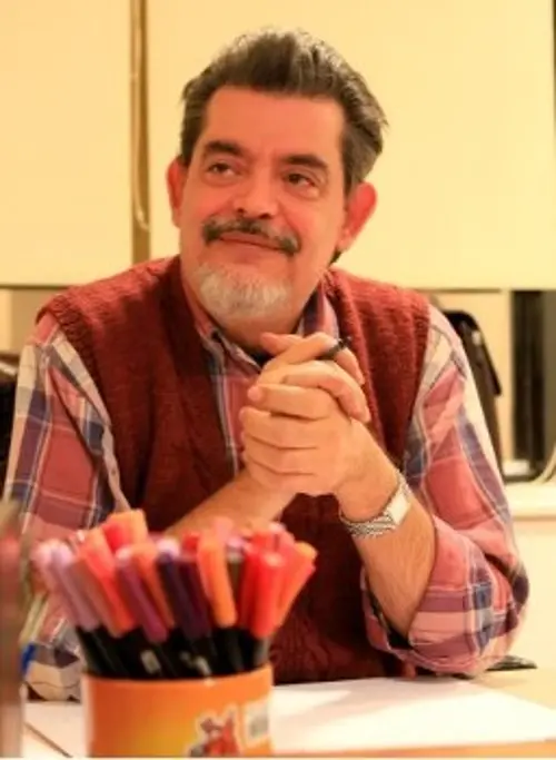 Ο Στάθης (Σταυρόπουλος) στο εργαστήριό του, έχοντας μπροστά του τα πενάκια του και τα μαρκαδοράκια του