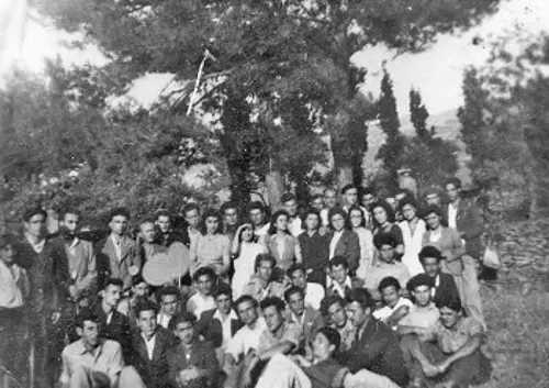 Μέλη της ΕΠΟΝ Ικαρίας, με το φως του ήλιου να τους χτυπάει καταπρόσωπο, εξ ου και μια νεαρή γυναίκα βάζει το χέρι αντήλιο