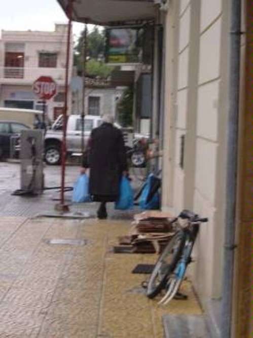 Η γιαγιά με τις δυο μπλε σακούλες που περιέχουν το κοτόπουλο, τα δυο λίτρα λάδι και τα υπόλοιπα ...αγαθά μόλις έχει βγεί από την Τράπεζα Τροφίμων