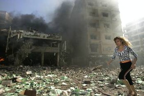 Μια γυναίκα τρέχει μέσα στα χαλάσματα, ενώ ο βομβαρδισμός μαίνεται στο Νότιο Λίβανο