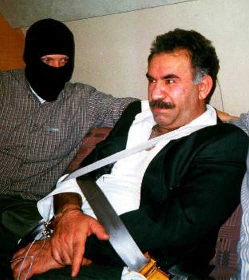 Ο Αμπντουλάχ Οτσαλάν στο αεροπλάνο που τον μεταφέρει από το Ναϊρόμπι στην Αγκυρα. Σιδηροδέσμιος, υπό την επήρεια ψυχοφαρμάκων, ανακρίνεται από τους άνδρες της ΜΙΤ