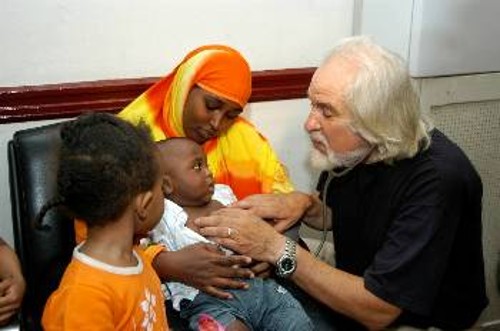 Επίσκεψη αντιπροσωπείας του ΠΑΜΕ σε ξενώνα Σομαλών προσφύγων. Γιατρός, στέλεχος του ΠΑΜΕ, εξετάζει παιδιά των μεταναστών