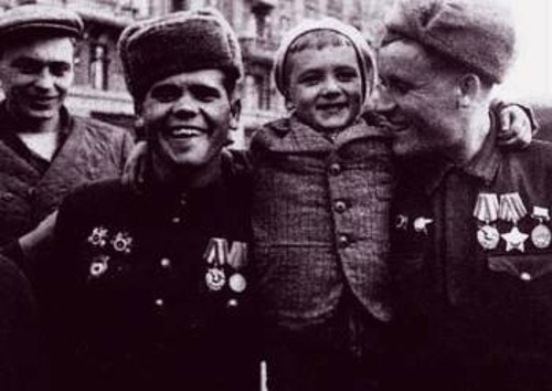 Δόξα στους ήρωες παρτιζάνους (στη φωτογραφία παρασημοφορημένοι αγωνιστές αγκαλιά με έναν πιτσιρικά στη λεωφόρο Πριμόρσκι)