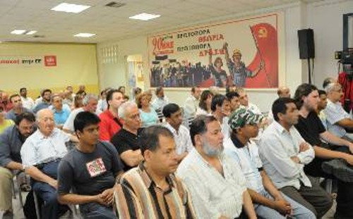 Μετανάστες εργάτες, μαζί με Ελληνες συναδέλφους τους, παρακολουθούν τη συνέντευξη Τύπου