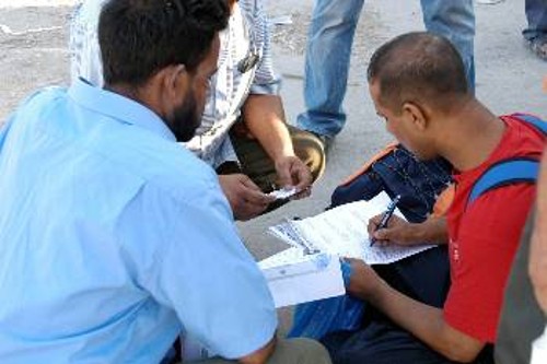Μετανάστες συμπληρώνουν τις αιτήσεις εγγραφής στο Σωματείο