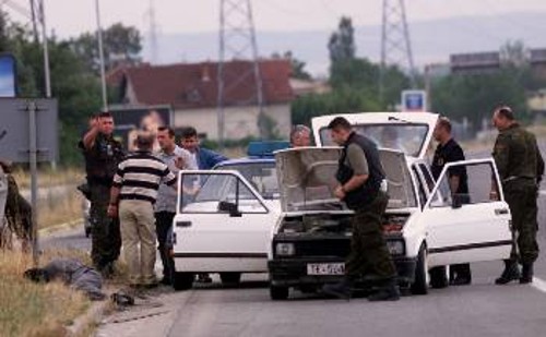 Αστυνομικοί της ΠΓΔΜ ελέγχουν διερχόμενο όχημα για όπλα, έξω από το Κουμάνοβο