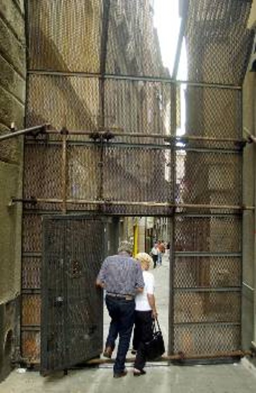 Ενα ζευγάρι προσπαθεί να περάσει από τη «σιδερόφραχτη πύλη», μία από τις πολλές που έχουν μετατρέψει σε φυλακή, ιδιαίτερα την «κόκκινη ζώνη»