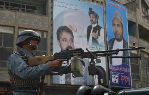 Αφγανός στρατιώτης πάνοπλος με φόντο... προεκλογικές αφίσες