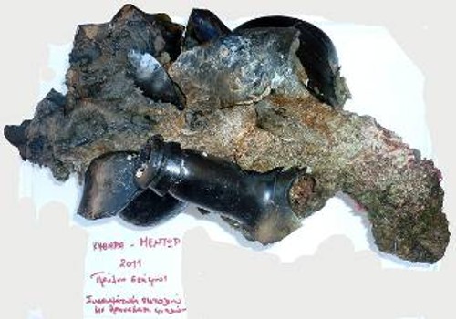 Θραύσματα φιαλών τα οποία βρέθηκαν στην πρύμνη του πλοίου, ενσωματωμένα με την πάροδο του χρόνου σε πιστόλα