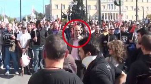 ...ο ίδιος φτάνει μπροστά από την περιφρούρηση του ΠΑΜΕ και χαμογελά προς το μπλοκ του 