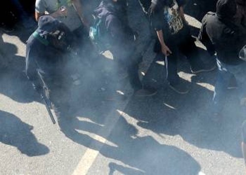 Ο προβοκάτορας εξοπλισμένος με αστυνομικό κλομπ, αντιασφυξιογόνα μάσκα και κουκούλα