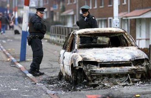 Αστυνομικοί κοιτούν το κατεστραμμένο αυτοκίνητο μετά τις συγκρούσεις