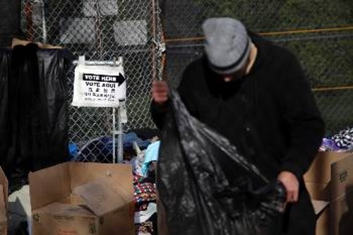 Κάτοικος της Νέας Υόρκης μετά την ψηφοφορία αναζητάει λίγα ζεστά ρούχα έξω από εκλογικό τμήμα