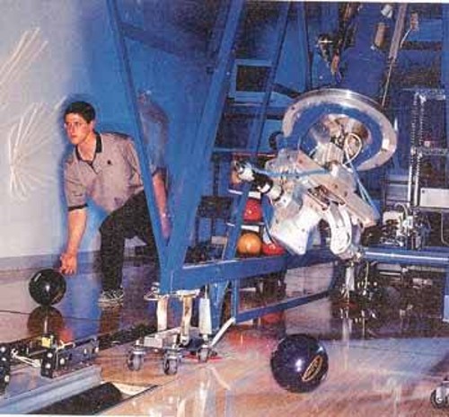 Το ρομπότ που παίζει μπόουλινγκ και δίπλα ένας από τους πρωταθλητές που το μηχάνημα χρησιμοποιεί σαν πρότυπο (φωτ. από το περιοδικό «Discover»)