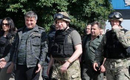 Ο φασίστας «πρόεδρος» Ο. Τουρτσίνοφ (στο κέντρο της φωτ., με το κράνος), που θα δώσει τη θέση του στον Ποροσένκο, επιθεωρεί τις δυνάμεις που χτυπάνε τις κατοικημένες περιοχές στην Ανατολή
