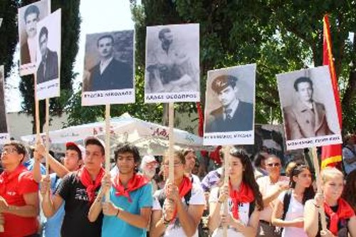 Μέλη της ΚΝΕ κρατούν πικέτες με πορτρέτα εκτελεσμένων