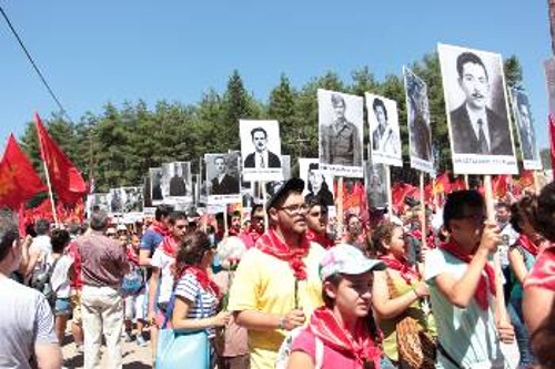 Νέοι της ΚΝΕ κρατούν πικέτες με πορτρέτα εκτελεσμένων, ανάμεσά τους μια ΚΝίτισα κρατούσε το πορτρέτο του παππού της