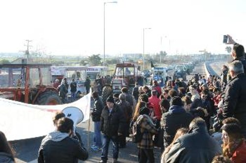 Εργάτες υποδέχονται τους αγρότες που φτάνουν στο μπλόκο με πανό και το σύνθημα «εργατιά - αγροτιά μια φωνή και μια γροθιά»