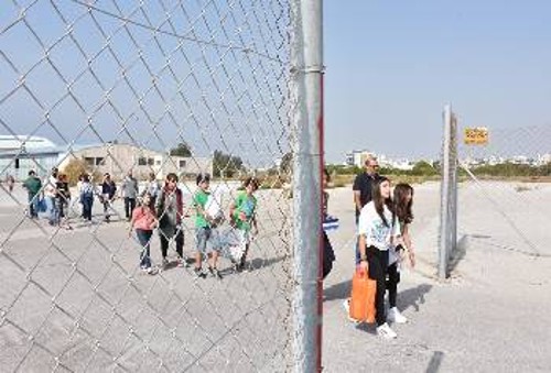 Μέλη της παιδικής θεατρικής ομάδας μεταφέρουν σακούλες με σχολικά είδη στα προσφυγόπουλα στο Ελληνικό