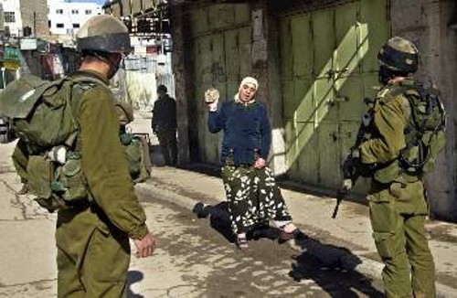 Αγανακτισμένη Παλαιστίνια κραδαίνει πέτρα στους ισραηλινούς στρατιώτες που δεν της επιτρέπουν να πάει σπίτι της