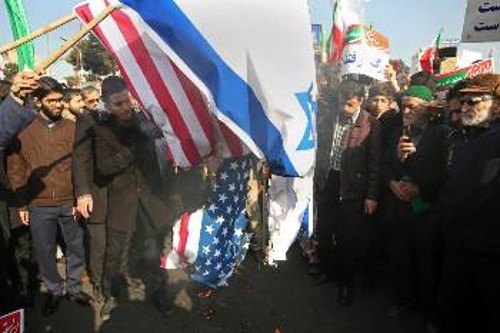 Οι σημαίες Ισραήλ και ΗΠΑ παραδόθηκαν στην πυρά διαδηλωτών χτες σε φιλοκυβερνητική διαδήλωση στο Μασχάντ