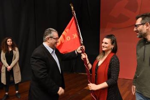 Η Τόνια Γαρδούνη, Γραμματέας της ΤΕ Χρηματοπιστωτικού, παραλαμβάνει τη σημαία του Κόμματος από τον Δ. Κουτσούμπα
