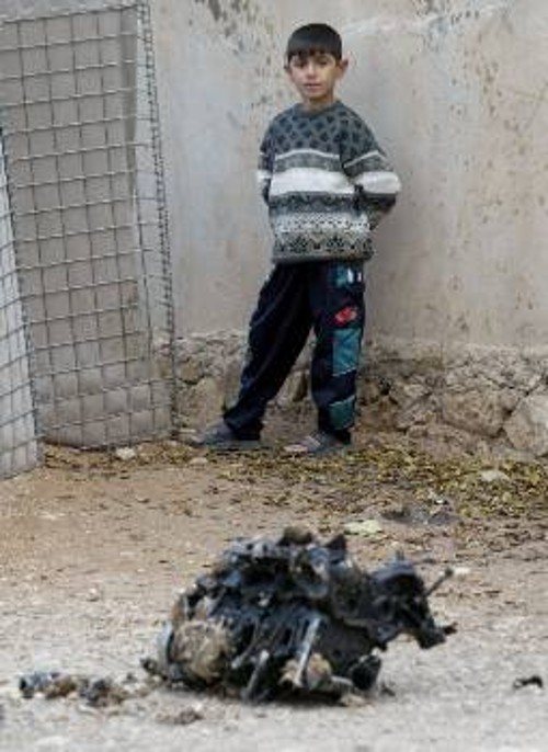 Μικρός Ιρακινός στέκεται μπροστά από τον κινητήρα του αυτοκινήτου που χρησιμοποιήθηκε στην επίθεση ενάντια στο κατοχικό στρατόπεδο στη Μοσούλη