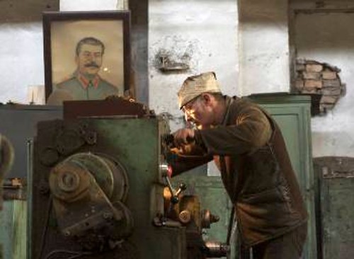 Με το πορτρέτο του Στάλιν δίπλα του στο μηχανουργείο στην Τιφλίδα...