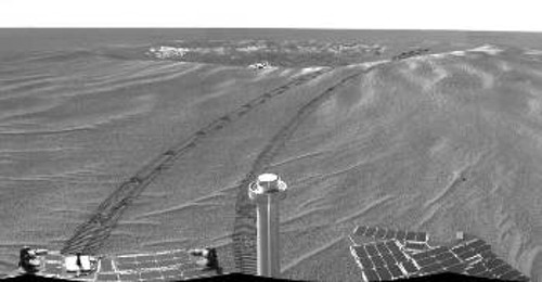 Το «Οπορτούνιτι» κοιτάζει πίσω του το μικρό κρατήρα μέσα στον οποίο κατέληξε κατά την προσεδάφισή του, μετά από αρκετές αναπηδήσεις στην επιφάνεια του Αρη (πάνω σε μπαλόνια που το περιέβαλαν)