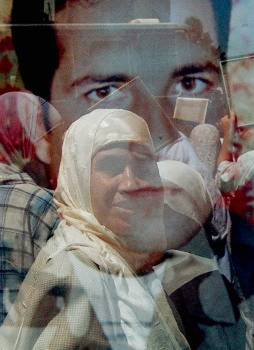 Παλαιστίνιες διαδηλώνουν με φόντο την αφίσα των φυλακισμένων απεργών πείνας