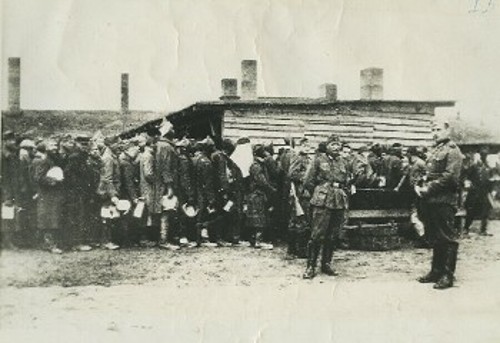 Φωτογραφίες τη στιγμή που το έγκλημα διαπράττεται και δεν μπορεί να σβηστεί από τη μνήμη. Κρατούμενοι των ναζιστικών στρατευμάτων, στο Στάλαγκ VI C, ακολουθούν ο ένας τον άλλον, με μαύρη υπομονή. Στην πρώτη ο προορισμός είναι άδηλος: Είτε θα βουλώσουν τις τρύπες από τους βομβαρδισμούς ή θα σκάψουν χαρακώματα. Στη δεύτερη, το συφοριασμένο δείπνο ελάχιστα θα τους βοηθήσει ν' ανακτήσουν την όποια δύναμη για την αυριανή καταδίκη