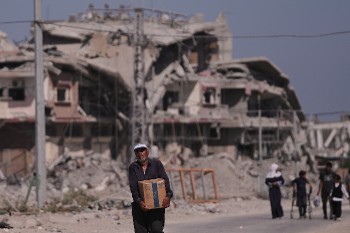 Κουβαλώντας λιγοστές προμήθειες στην πεινασμένη οικογένεια, στη Χαν Γιουνίς