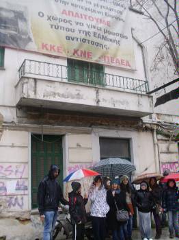 Κάτω από τη βροχή, έξω από το σπίτι που στέγαζε το παράνομο τυπογραφείο του ΚΚΕ