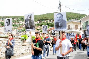 Νεολαίοι στην προσυγκέντρωση κρατούν πικέτες με τις μορφές μαχητών του ΔΣΕ στην περιοχή