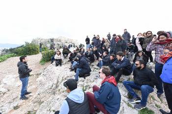 Οι νέοι κομμουνιστές κάτω από το Βράχο της Ακρόπολης μαθαίνουν την ιστορία της μάχης της Αθήνας