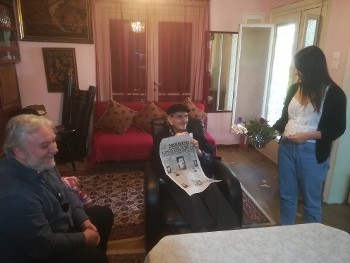 Ο αντιστασιακός ζωγράφος - χαράκτης Γιώργος Φαρσακίδης παραλαμβάνει τον «Ριζοσπάστη» και ένα κόκκινο γαρίφαλο