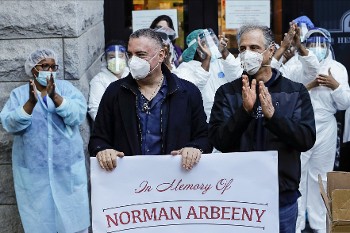 Από εκδήλωση σε κλινική στη Νέα Υόρκη: Οι εικονιζόμενοι σε πρώτο πλάνο προσέφεραν στο υγειονομικό προσωπικό 100 μάσκες υψηλής προστασίας, στη μνήμη του αδελφού τους, που έχασε τη μάχη με τον κορονοϊό