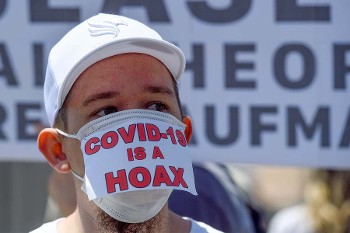 Οπαδός θεωριών συνωμοσίας διαδηλώνει την πεποίθησή του ότι «η COVID-19 είναι μια απάτη»