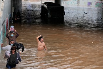 Λεωφορείο της γραμμής Βούλα - Πειραιάς και επιβάτες που προσπαθούν να βγουν από τα νερά στην Καλλιθέα στο ύψος του υπερσύγχρονου Ιδρύματος «Σταύρος Νιάρχος»