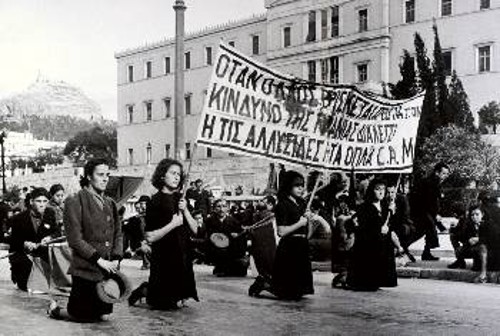 Αθήνα 4 Δεκέμβρη 1944. Χιλιάδες λαού στην κηδεία των θυμάτων της προηγούμενης μέρας. Ανάμεσά τους τα μαυροφορεμένα κορίτσια, κρατώντας το πανό που έγραφε: «Οταν ο λαός βρίσκεται μπροστά στον κίνδυνο της τυραννίας διαλέγει ή τις αλυσίδες ή τα όπλα - ΕΑΜ»