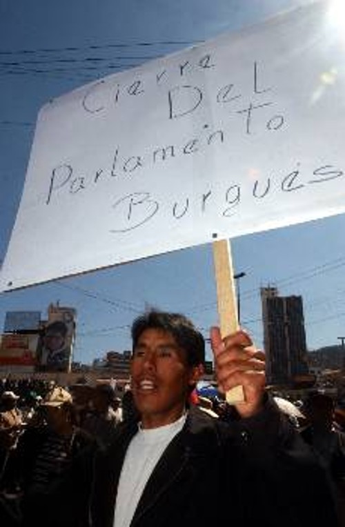 Βολιβιανός διαδηλωτής με εύλογο πλακάτ που ζητάει «Να κλείσει η Βουλή των αστών»